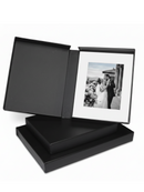 Black archival photo album with a black and white photograph inside on a white background